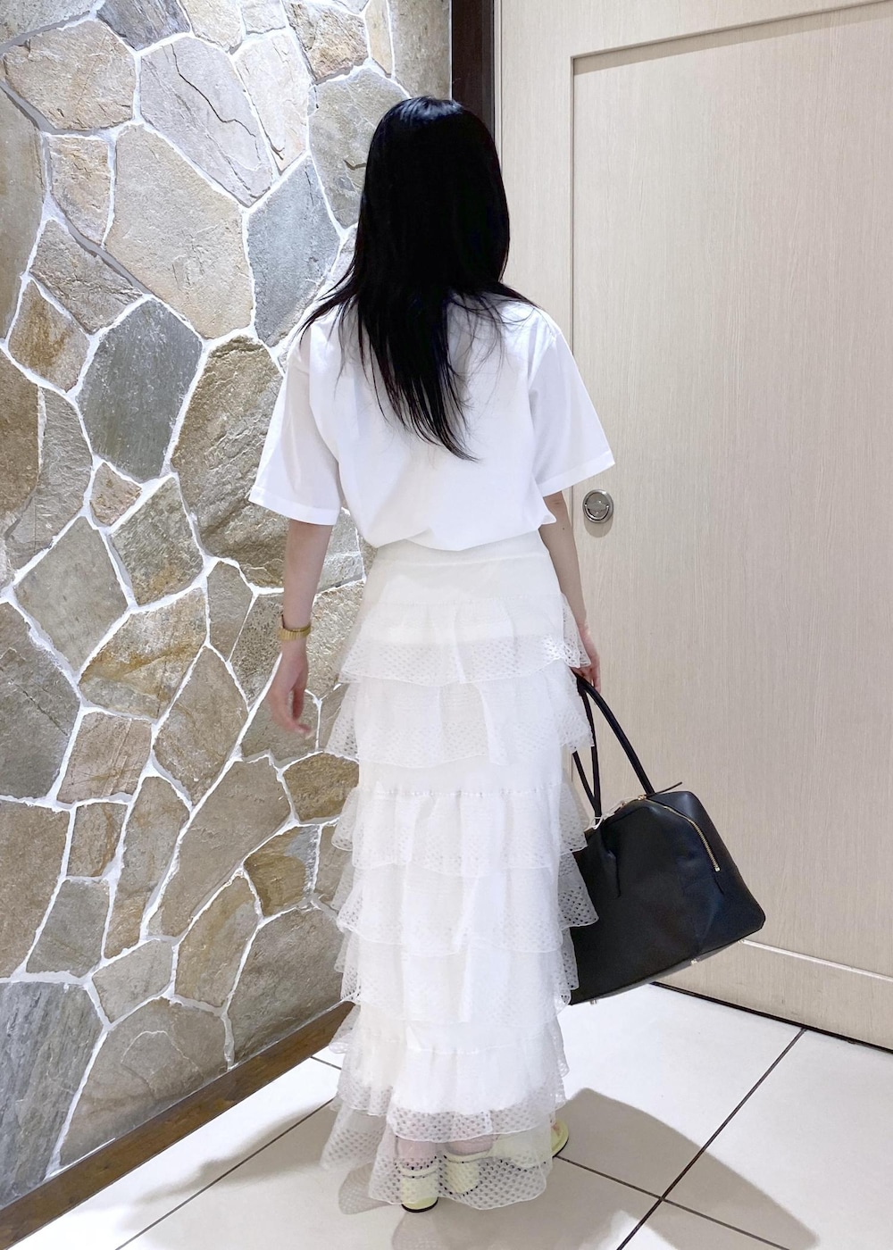 グリーン系のサンダル、ホワイト系のスカート、ブラック系のボストンバッグを着用したレディースの夏コーディネートの5枚目の写真