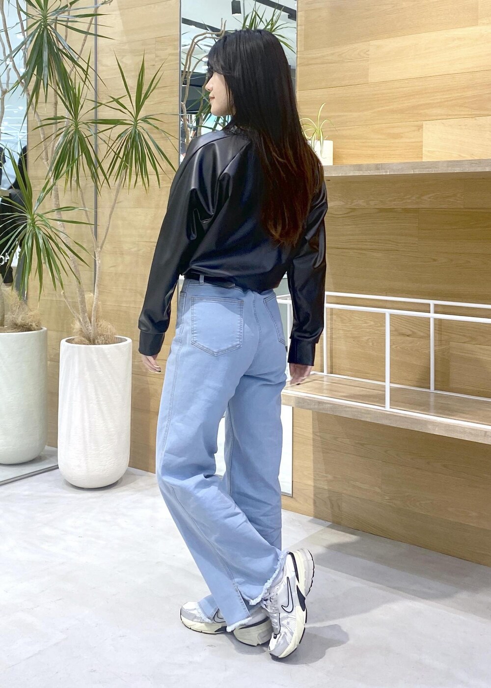 ブラック系のその他トップス、ブルー系のデニムパンツ、ホワイト系のスニーカーを着用したレディースの秋コーディネートの8枚目の写真