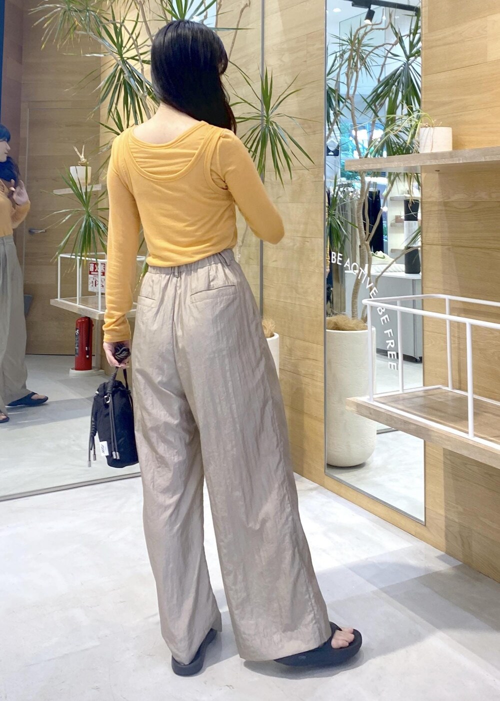 ブラック系のサンダル、ベージュ系のその他パンツ、オレンジ系のアンサンブルを着用したレディースの夏コーディネートの8枚目の写真