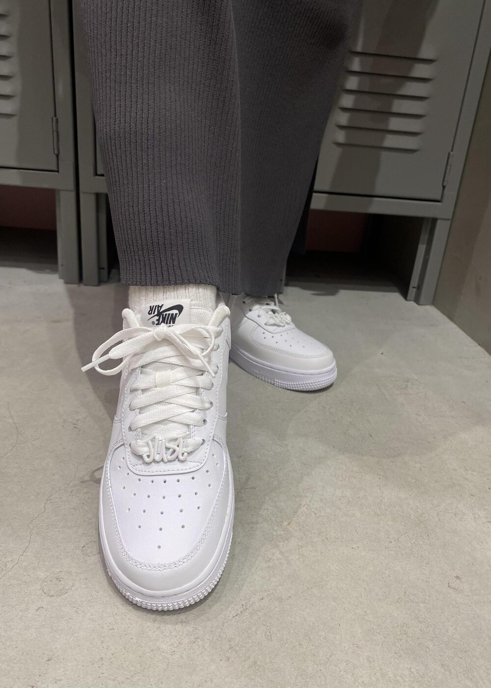 ホワイト系のパーカー、ホワイト系のスニーカー、ブラック系のワンピースを着用したレディースの冬コーディネートの5枚目の写真