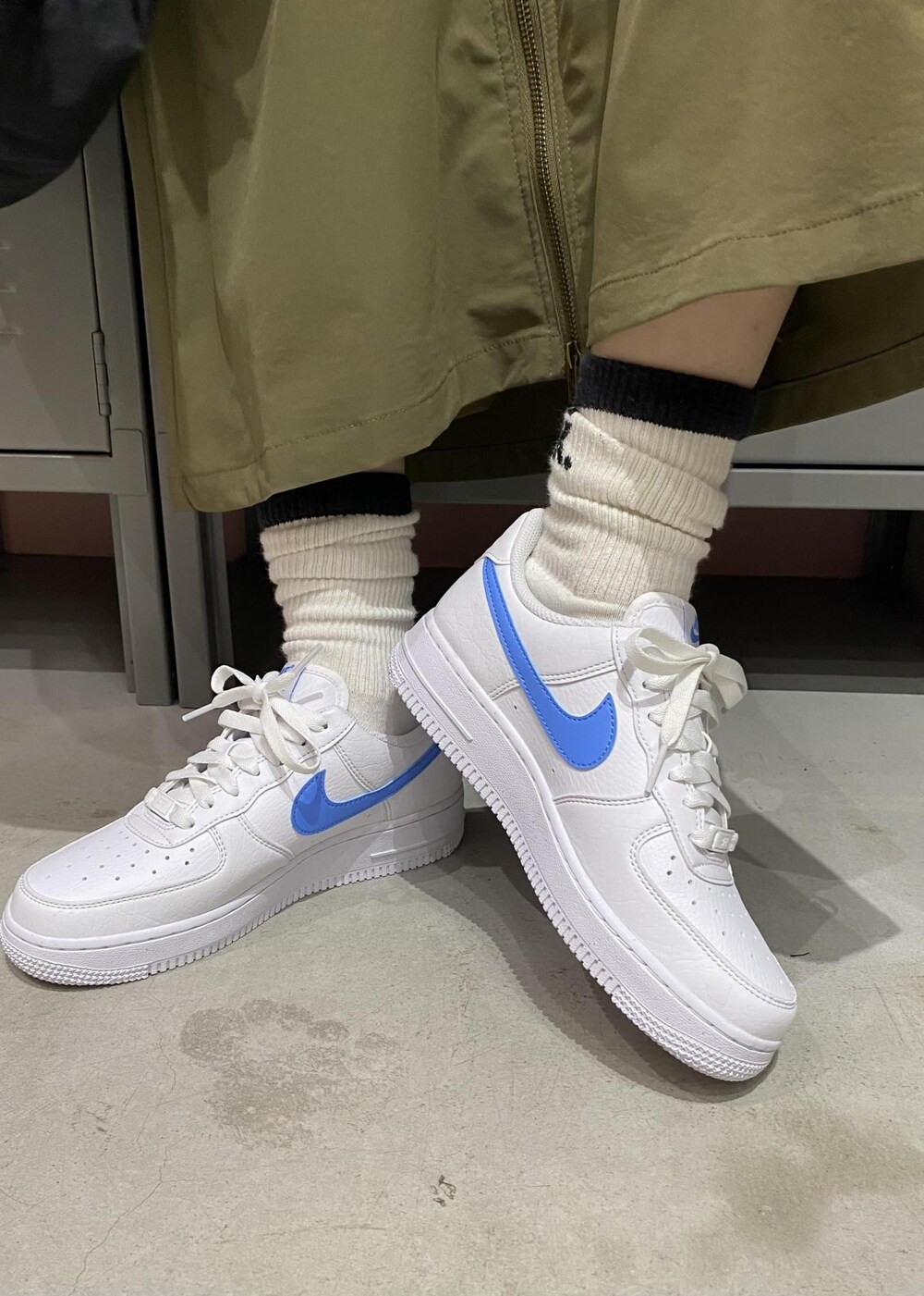 グリーン系のスカート、ブルー系のブルゾン、ブラック系のTシャツ/カットソーを着用したレディースの春コーディネートの6枚目の写真