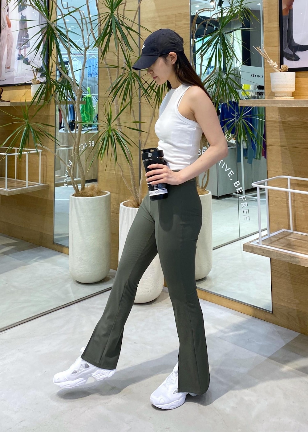 ホワイト系のスニーカー、ホワイト系のタンクトップ、ブラック系のキャップを着用したレディースの夏コーディネートの4枚目の写真