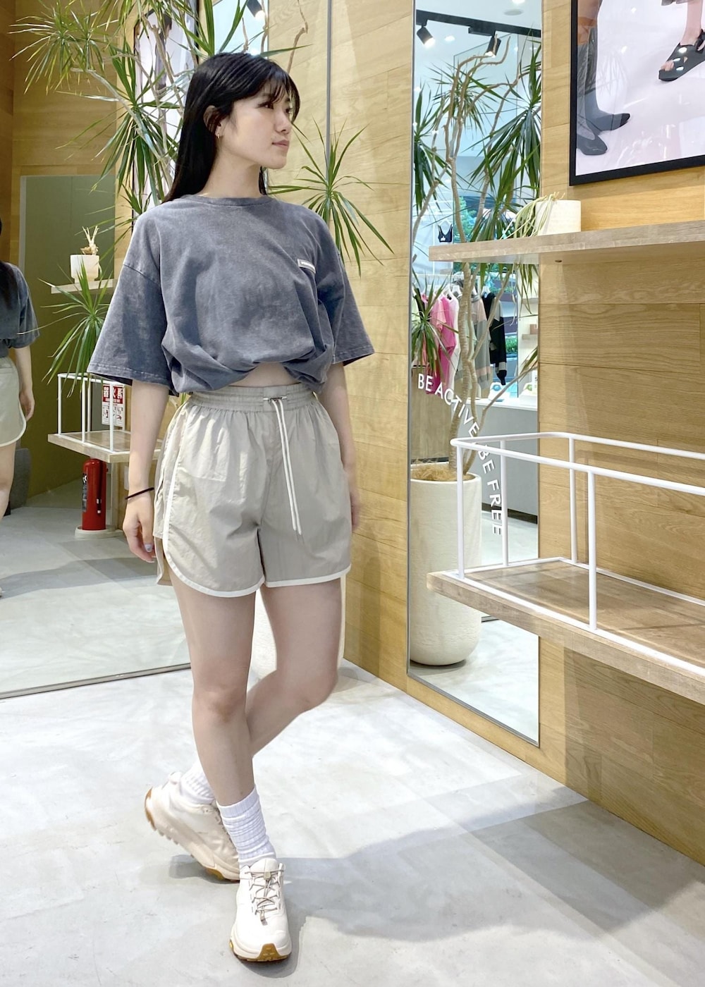 ブラック系のTシャツ/カットソー、ベージュ系のその他パンツ、ホワイト系のスニーカーを着用したレディースの夏コーディネートの4枚目の写真