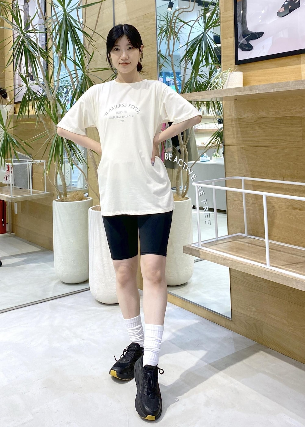 ホワイト系のTシャツ/カットソー、ブラック系のスニーカー、ブラック系のレギンス/スパッツを着用したレディースの夏コーディネートの5枚目の写真