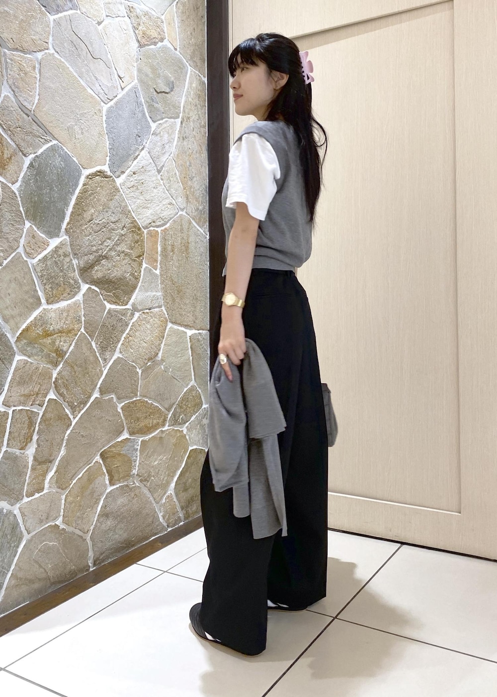 ブラック系のスニーカー、グレー系のニット/セーター、ブラック系のスラックスを着用したレディースの秋コーディネートの3枚目の写真