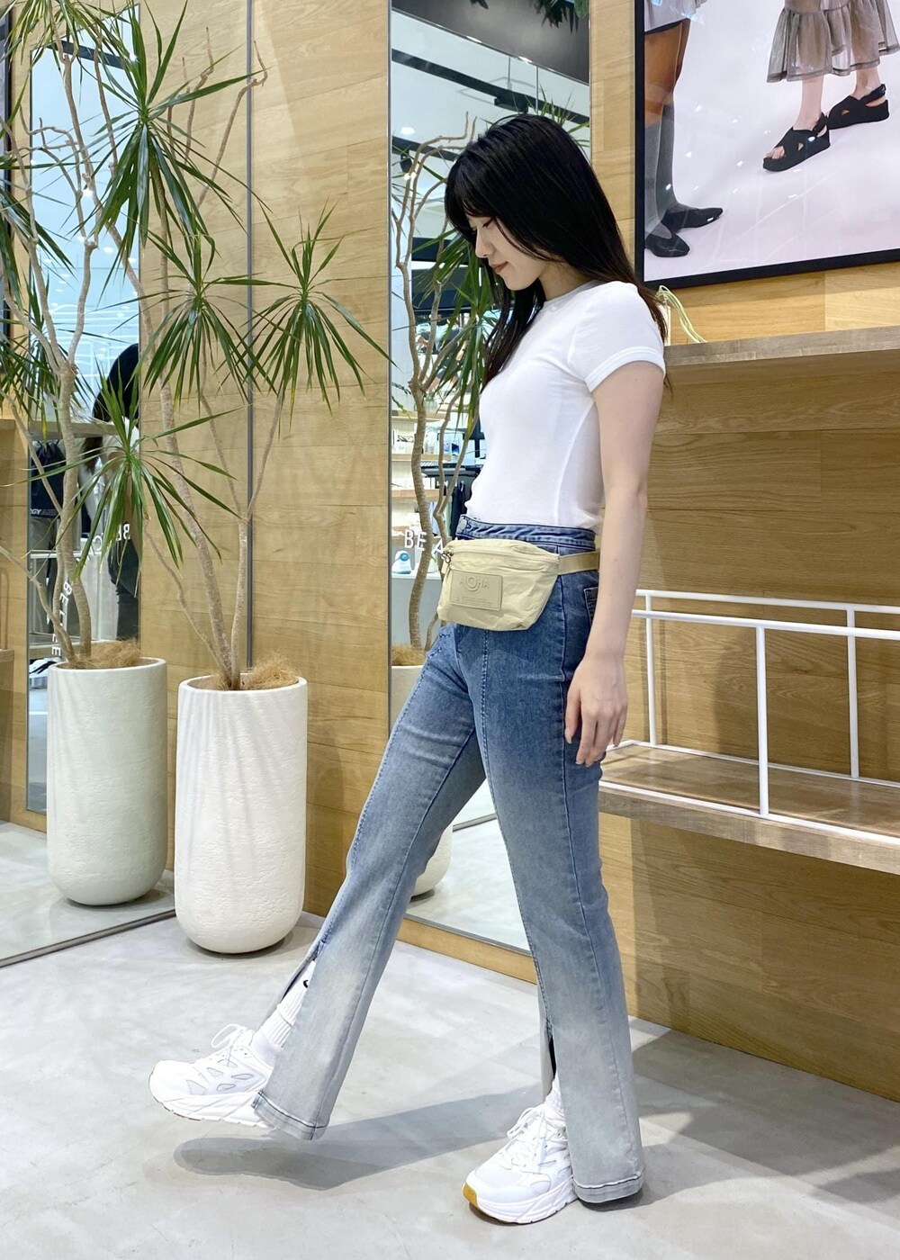 ブルー系のデニムパンツ、ホワイト系のスニーカー、ホワイト系のTシャツ/カットソーを着用したレディースの夏コーディネートの3枚目の写真