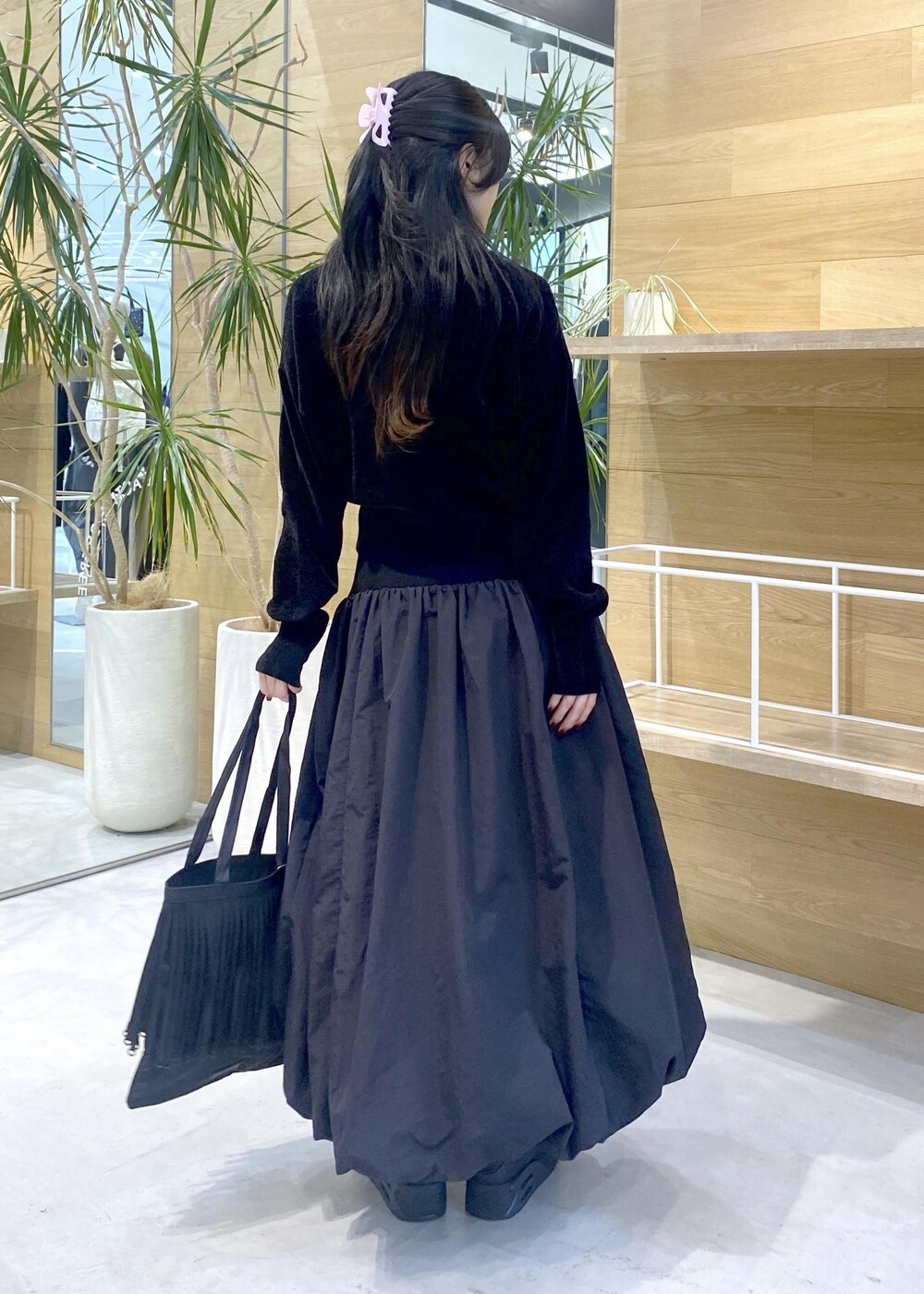 ブラック系のスカート、ブラック系のカーディガン/ボレロ、ブラック系のスニーカーを着用したレディースの冬コーディネートの7枚目の写真