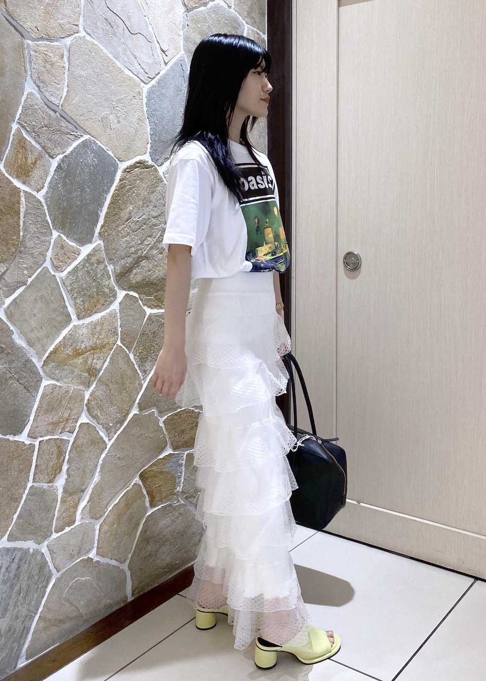グリーン系のサンダル、ホワイト系のスカート、ブラック系のボストンバッグを着用したレディースの夏コーディネートの4枚目の写真