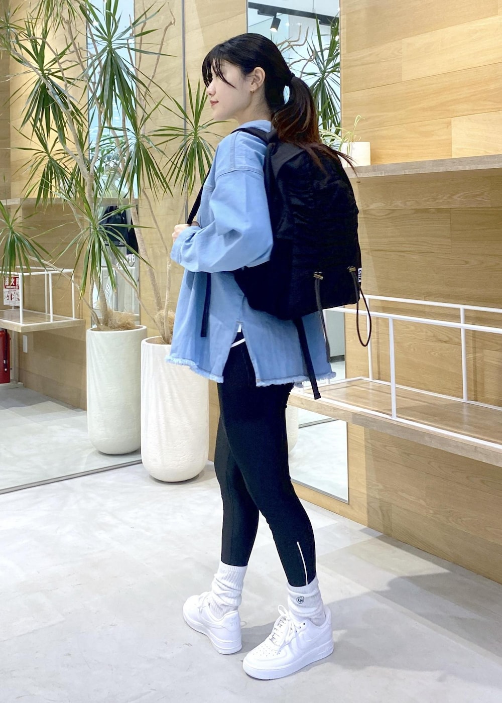 ホワイト系のスニーカー、ブルー系のパーカー、ブラック系のバックパック/リュックを着用したレディースの秋コーディネートの5枚目の写真
