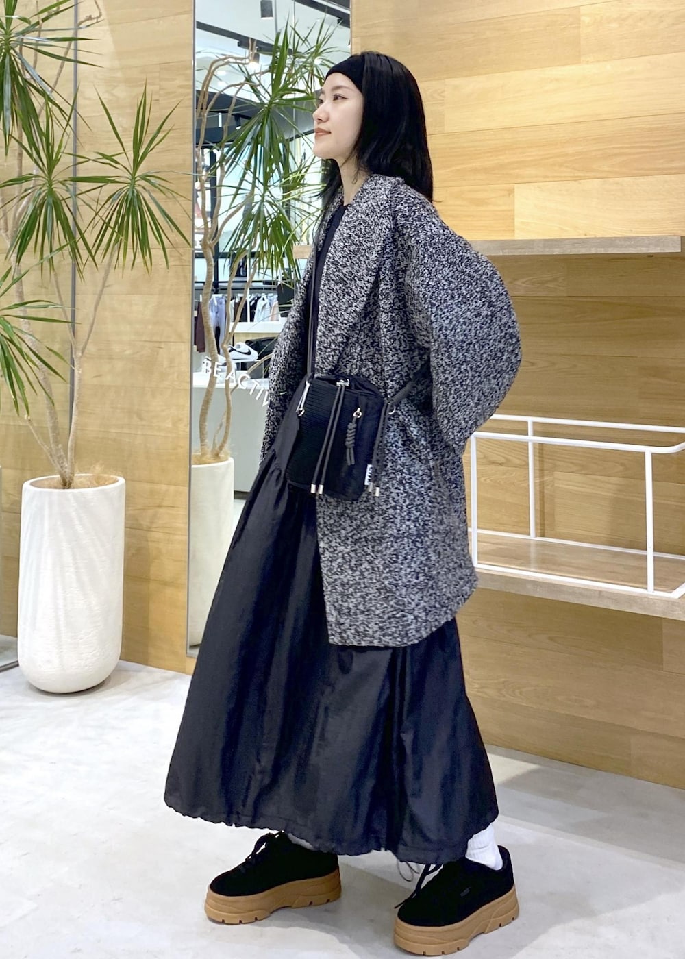 ブラック系のショルダーバッグ、ブラック系のワンピース、ブラック系のチェスターコートを着用したレディースの秋コーディネートの2枚目の写真