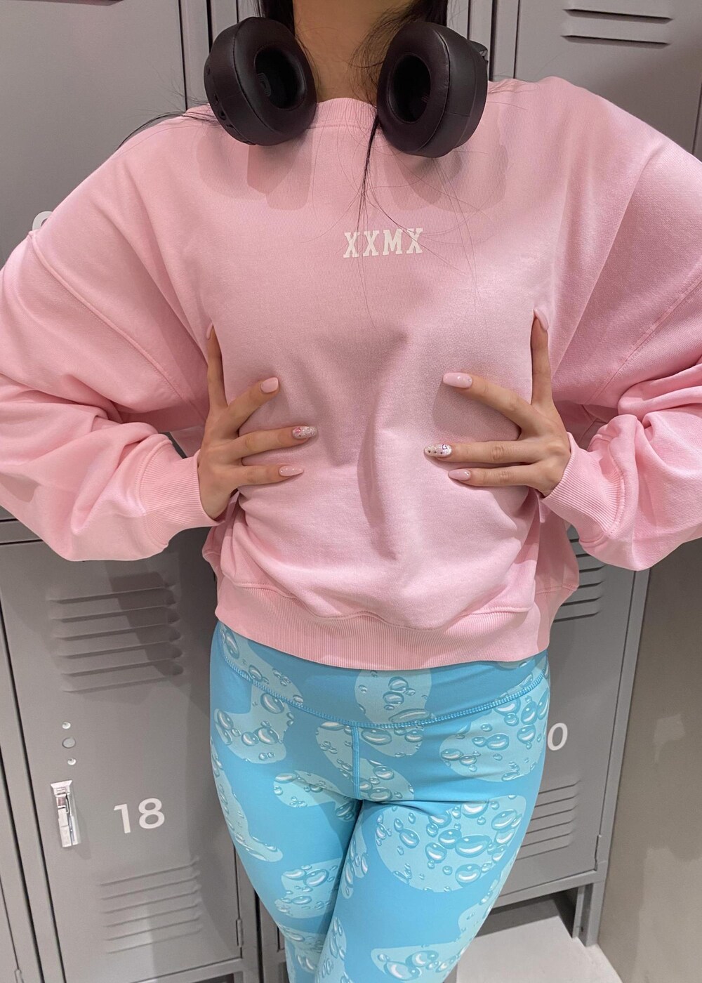 ピンク系のスウェット、ホワイト系のスニーカー、ブルー系のレギンス/スパッツを着用したレディースの冬コーディネートの5枚目の写真