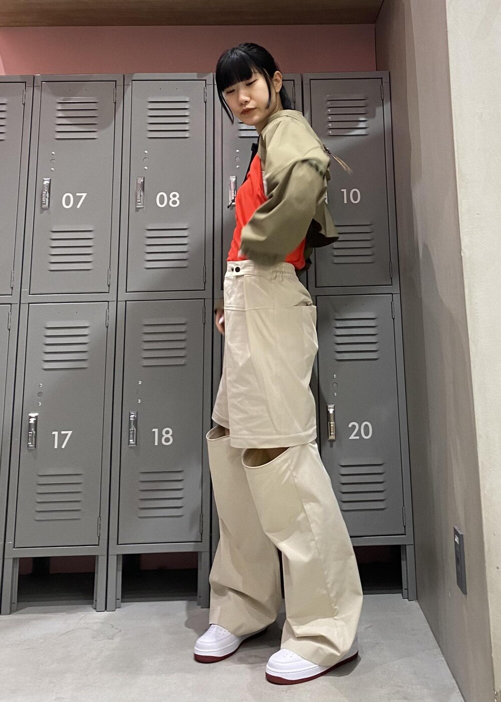 ホワイト系のスニーカー、レッド系のタンクトップ、グレー系のその他パンツを着用したレディースの冬コーディネートの4枚目の写真