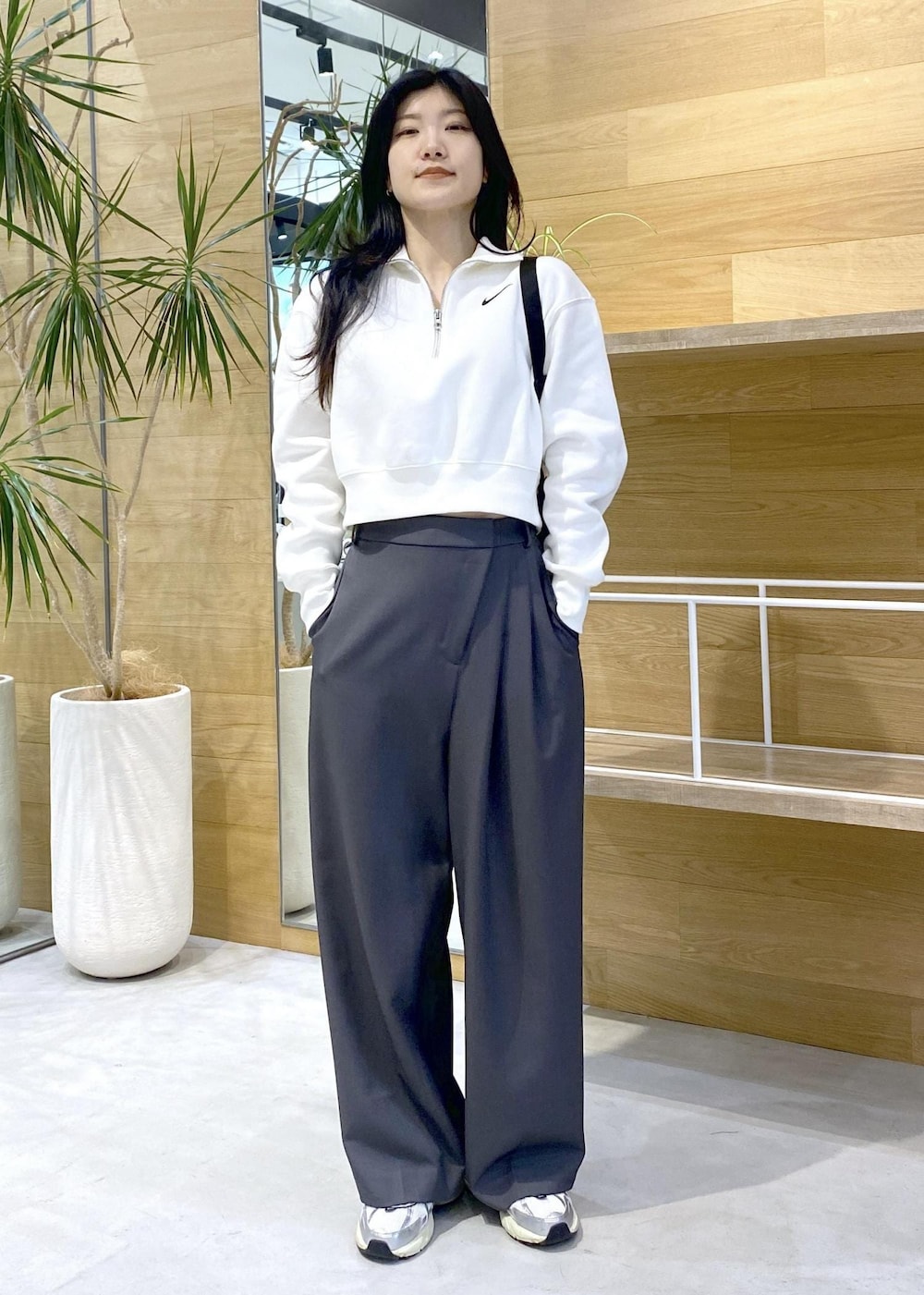 グレー系のスラックス、ホワイト系のスニーカーを着用したレディースの秋コーディネートの7枚目の写真