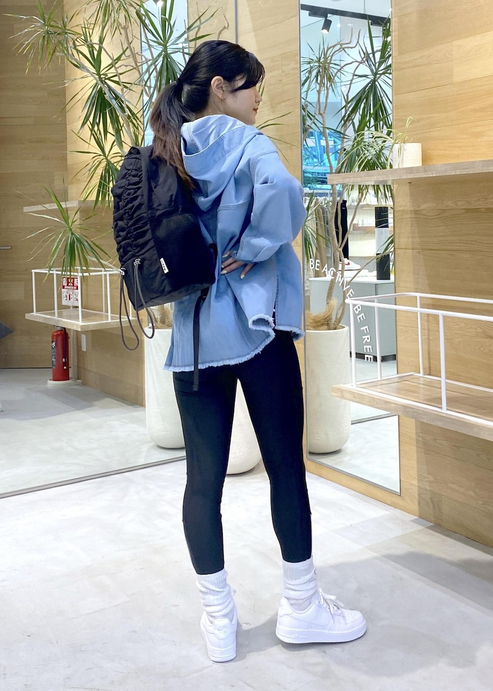 ホワイト系のスニーカー、ブルー系のパーカー、ブラック系のバックパック/リュックを着用したレディースの秋コーディネートの3枚目の写真