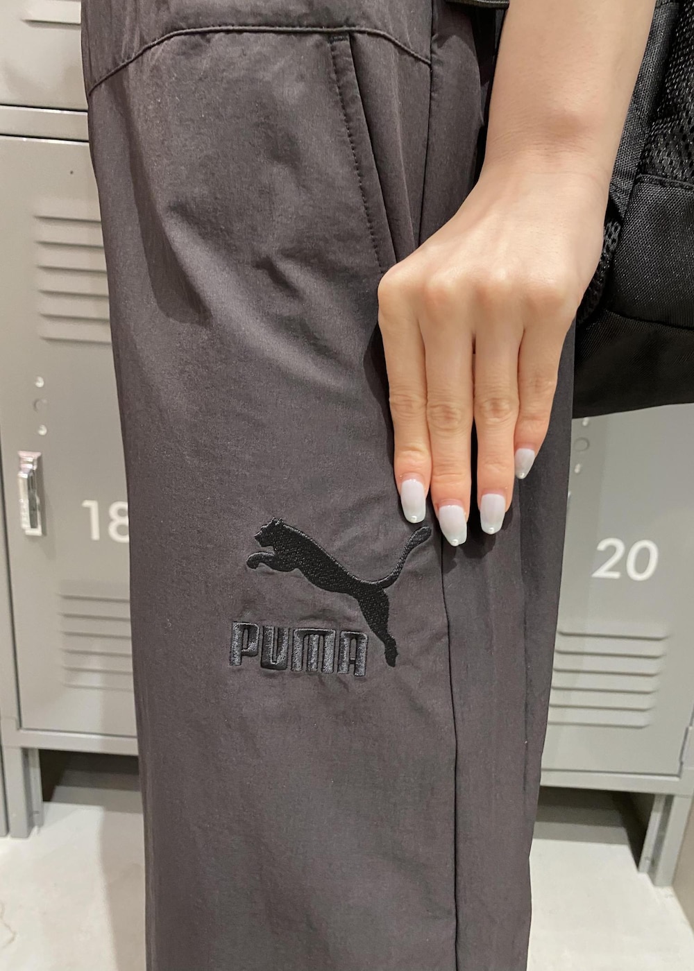 ホワイト系のスニーカー、ブラック系のワンピース、ブラック系のマウンテンパーカーを着用したレディースの春コーディネートの3枚目の写真