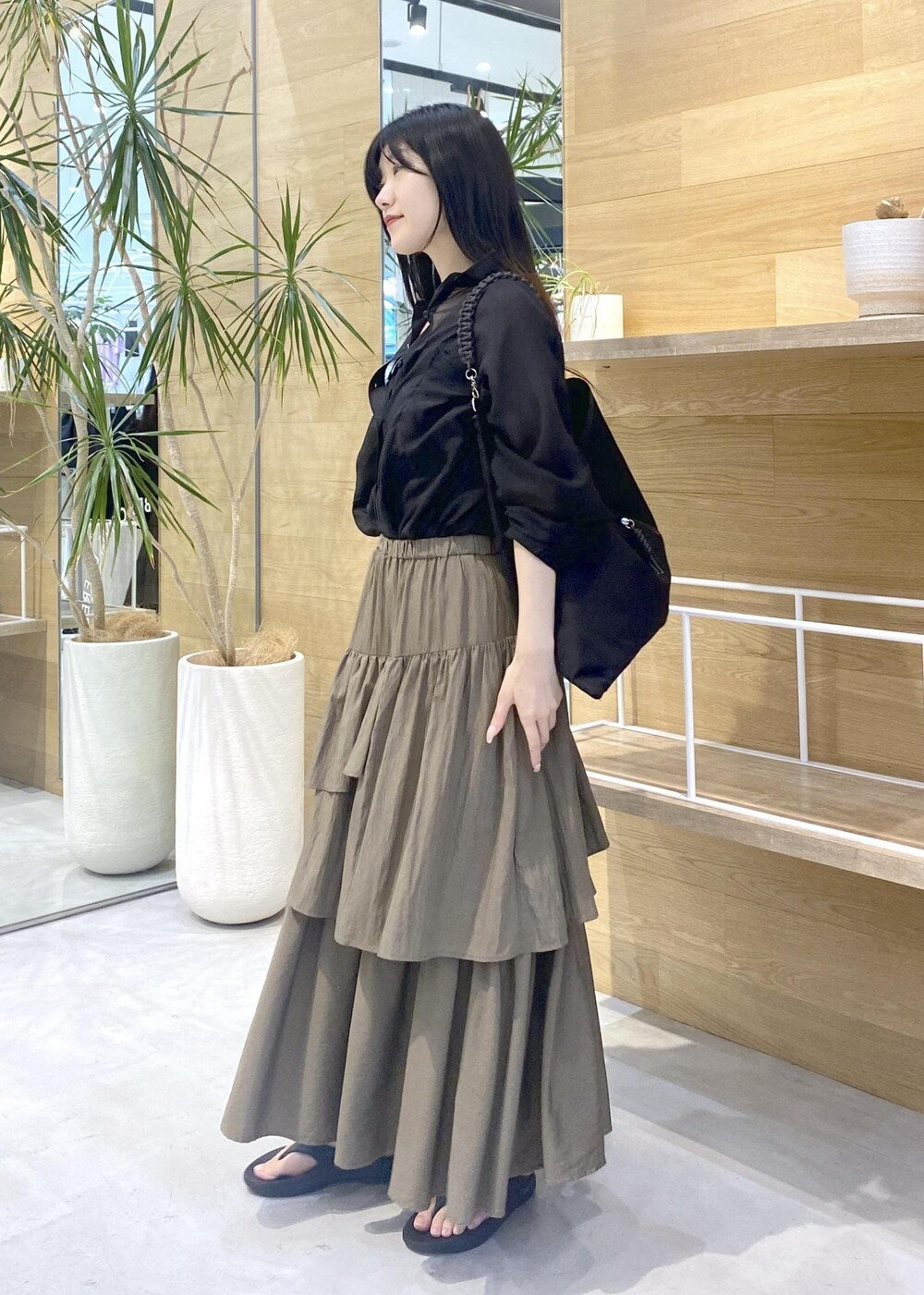 グリーン系のスカート、ブラック系のキャミソール、ブラック系のサンダルを着用したレディースの夏コーディネートの3枚目の写真