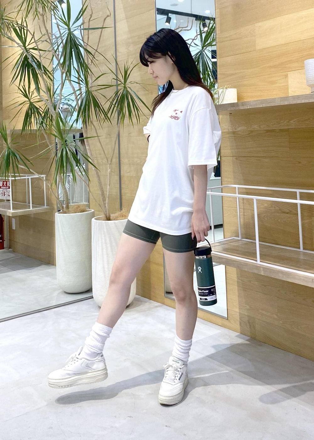 ホワイト系のスニーカー、ホワイト系のTシャツ/カットソー、グリーン系のレギンス/スパッツを着用したレディースの夏コーディネートの2枚目の写真
