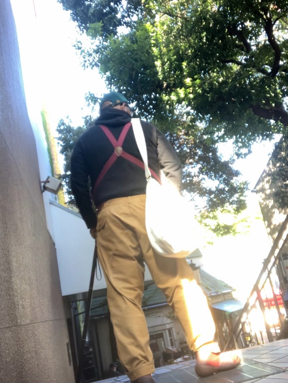 ベージュ系のショルダーバッグ、ブラウン系のスリッポン、ブルー系のキャップを着用したメンズの秋コーディネートの3枚目の写真