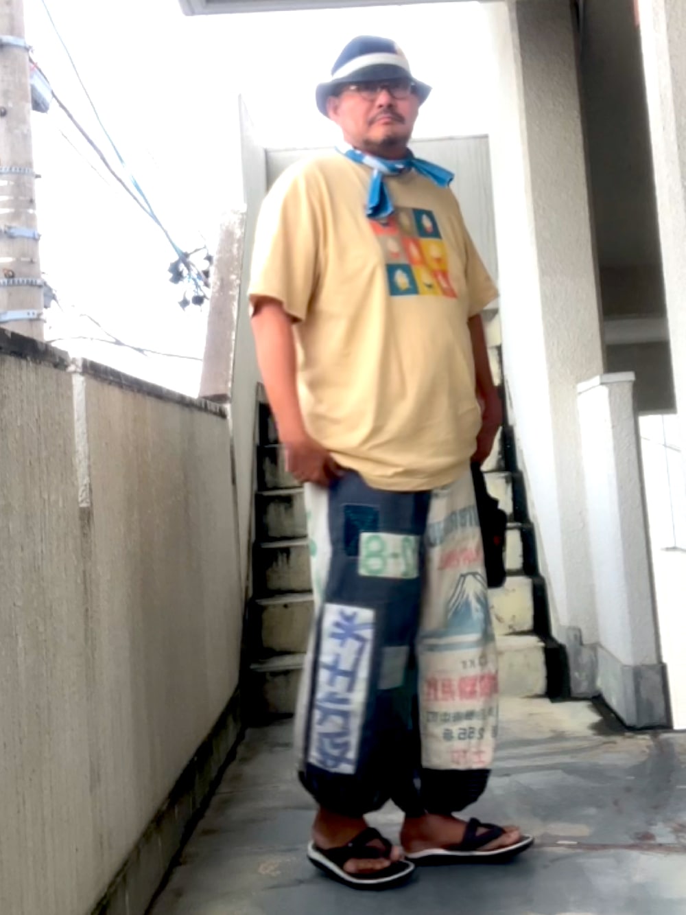 ベージュ系のTシャツ/カットソー、その他のその他パンツ、ブルー系のハットを着用したメンズの夏コーディネートの2枚目の写真