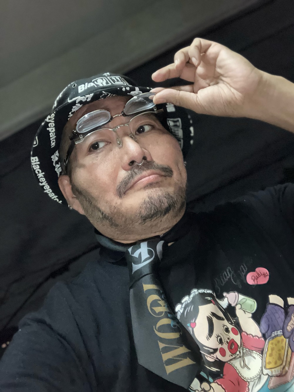 ブラック系のTシャツ/カットソー、ブラック系のネクタイ、ブラック系のスリッポンを着用したメンズの秋コーディネートの4枚目の写真