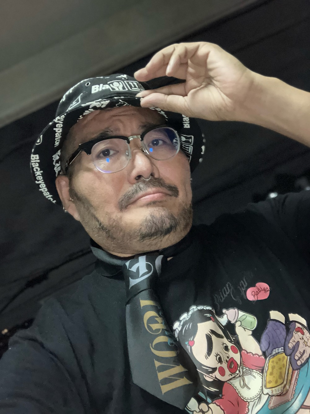 ブラック系のTシャツ/カットソー、ブラック系のネクタイ、ブラック系のスリッポンを着用したメンズの秋コーディネートの5枚目の写真