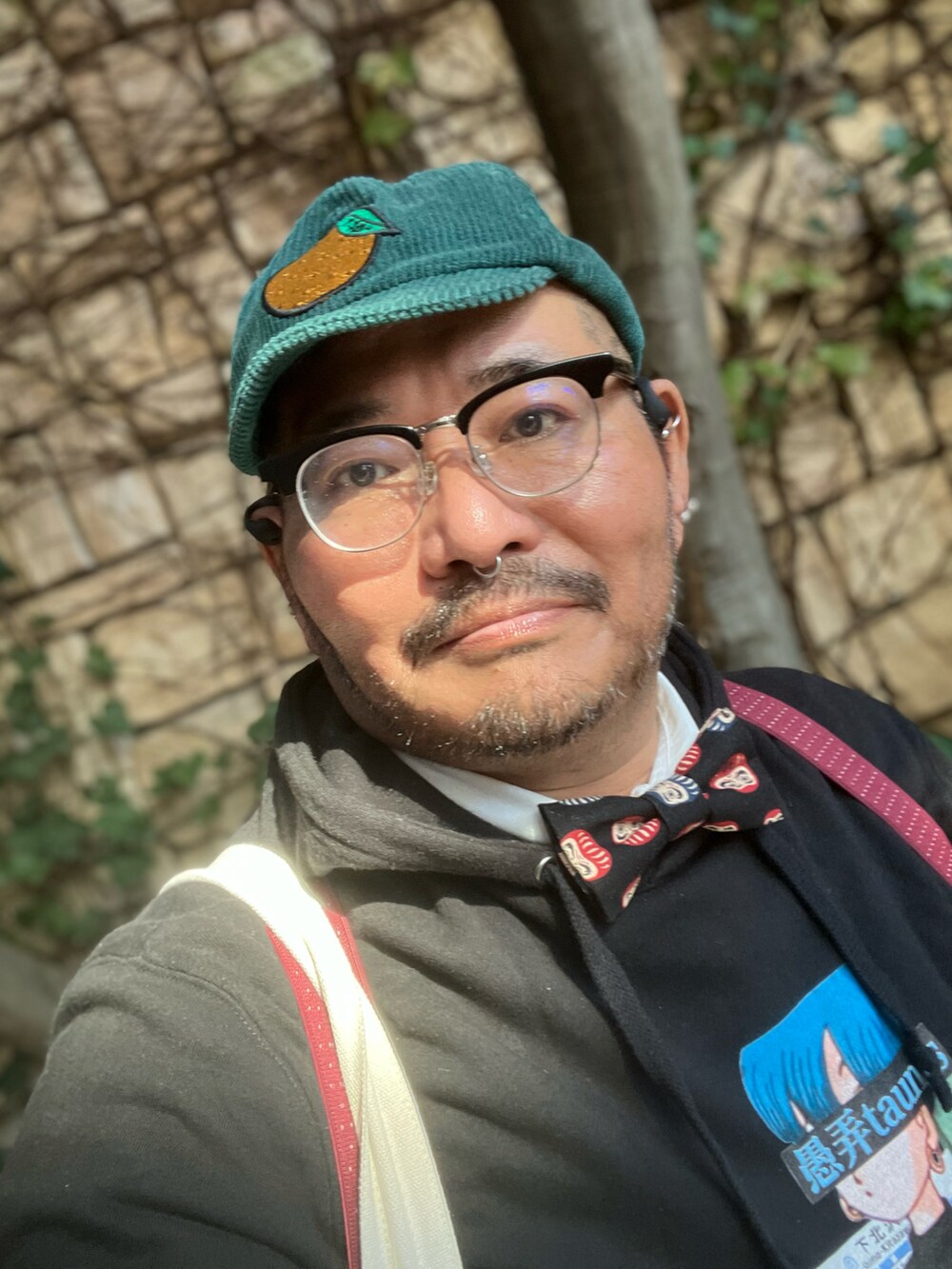 ベージュ系のショルダーバッグ、ブラウン系のスリッポン、ブルー系のキャップを着用したメンズの秋コーディネートの5枚目の写真