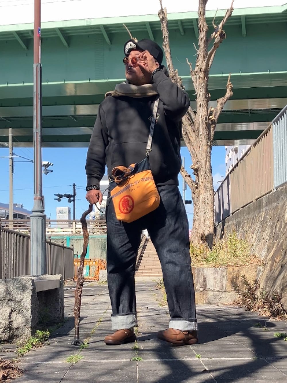ブラック系のパーカー、ブラウン系のスリッポン、ブルー系のデニムパンツを着用したメンズの冬コーディネートの2枚目の写真