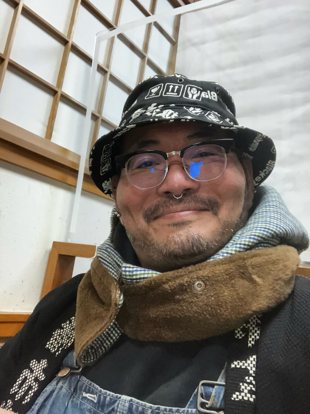 レッド系のバッグ、レッド系のスニーカー、ブラック系のハットを着用したメンズの冬コーディネートの3枚目の写真