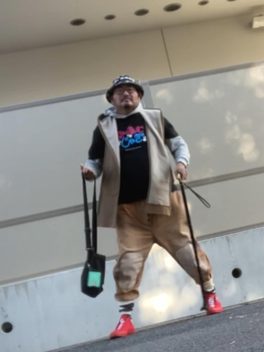 ブラック系のTシャツ/カットソー、グレー系のパーカー、レッド系のスニーカーを着用したメンズの秋コーディネートの2枚目の写真