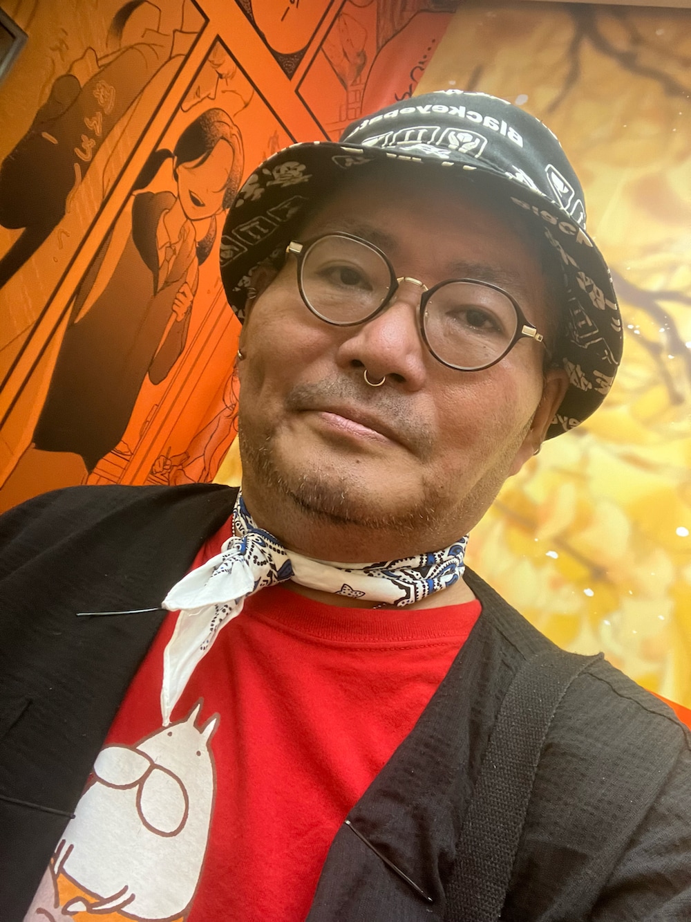 レッド系のショルダーバッグ、レッド系のスリッポン、ブラック系のハットを着用したメンズの秋コーディネートの5枚目の写真