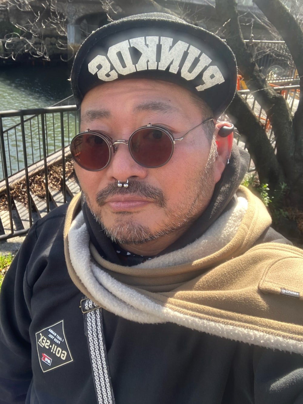 ブラック系のパーカー、ブラウン系のスリッポン、ブルー系のデニムパンツを着用したメンズの冬コーディネートの5枚目の写真