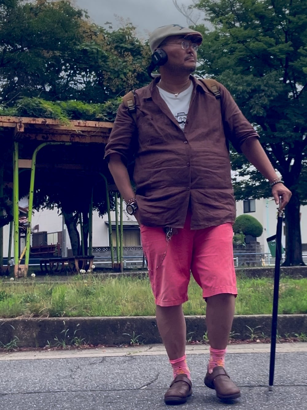 ブラウン系のスリッポン、ピンク系のその他パンツ、ホワイト系のTシャツ/カットソーを着用したメンズの夏コーディネートの2枚目の写真