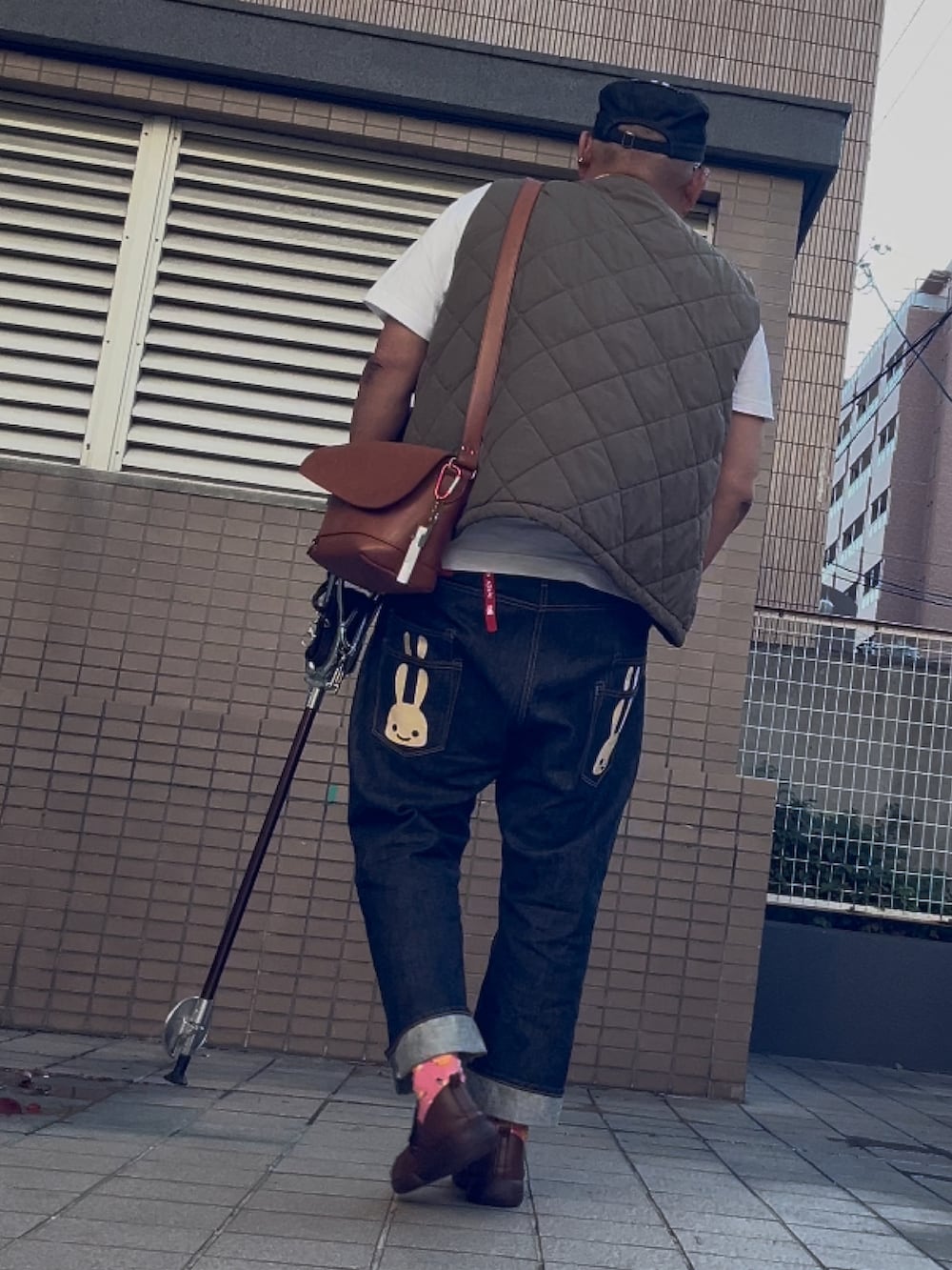ブルー系のデニムパンツ、ホワイト系のTシャツ/カットソー、ブラウン系のスリッポンを着用したメンズの秋コーディネートの4枚目の写真