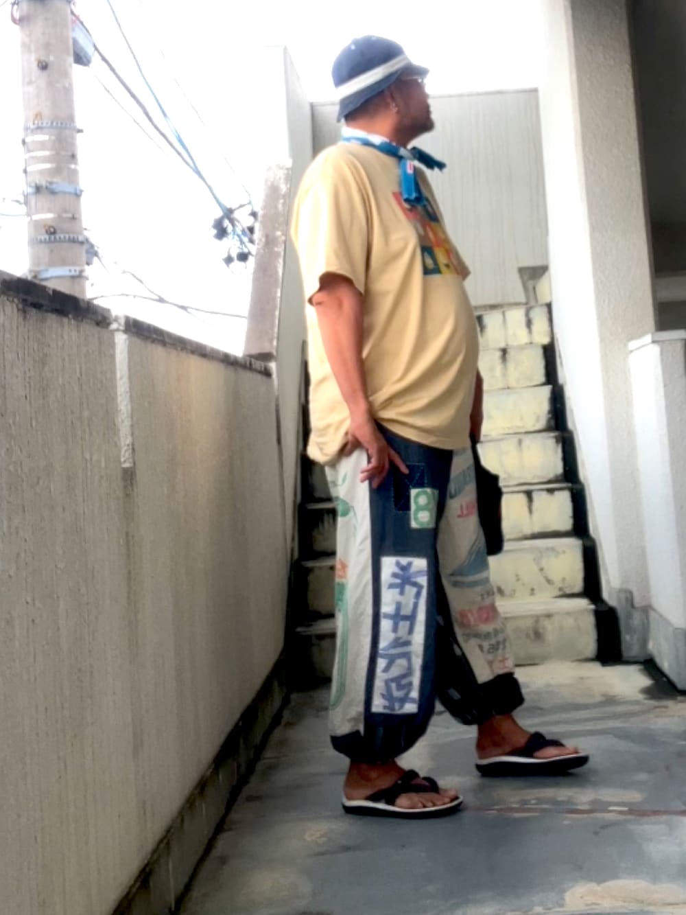 ベージュ系のTシャツ/カットソー、その他のその他パンツ、ブルー系のハットを着用したメンズの夏コーディネートの3枚目の写真