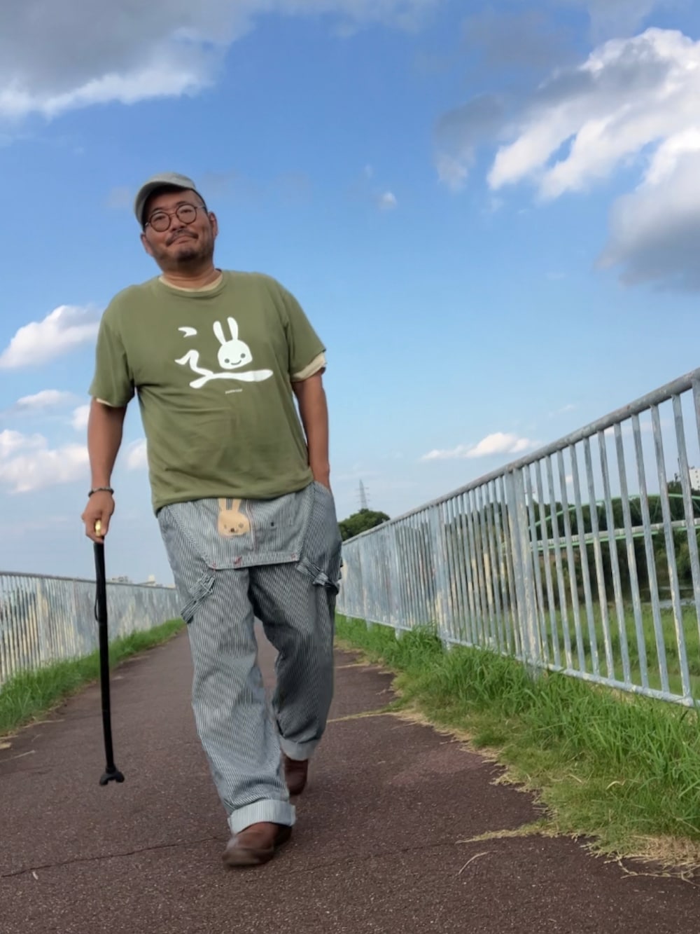 その他のサロペット/オーバーオール、グリーン系のTシャツ/カットソー、ベージュ系のショルダーバッグを着用したメンズの秋コーディネートの3枚目の写真