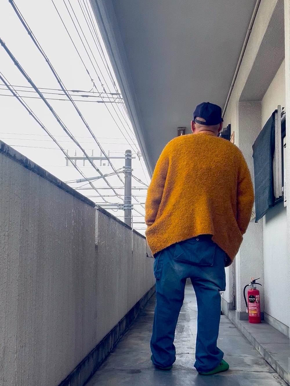 ブルー系のスウェット、グリーン系のスリッポン、ブルー系のキャップを着用したメンズの冬コーディネートの3枚目の写真