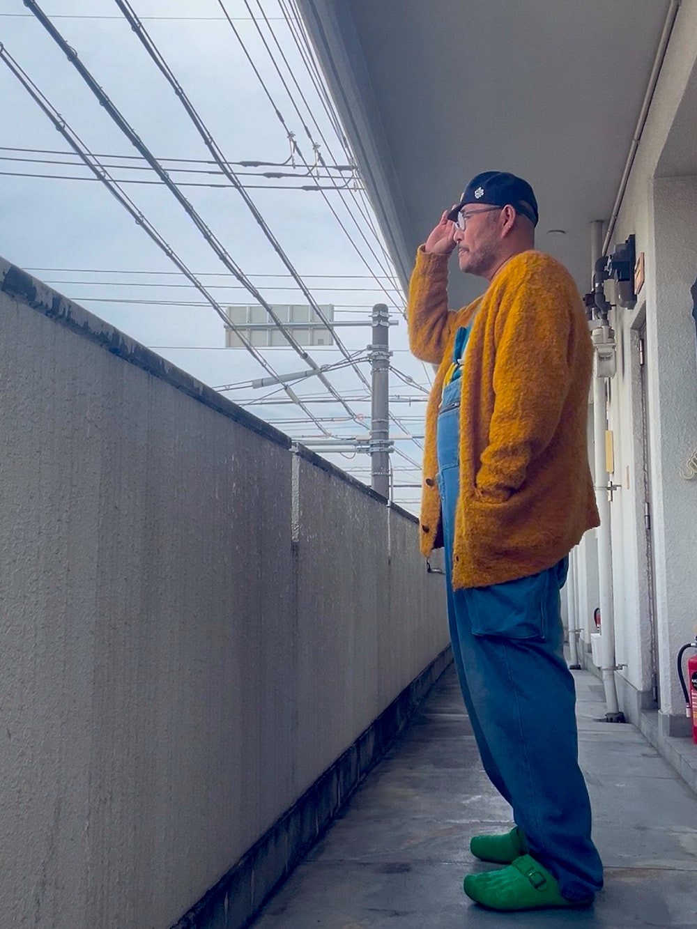 ブルー系のスウェット、グリーン系のスリッポン、ブルー系のキャップを着用したメンズの冬コーディネートの2枚目の写真