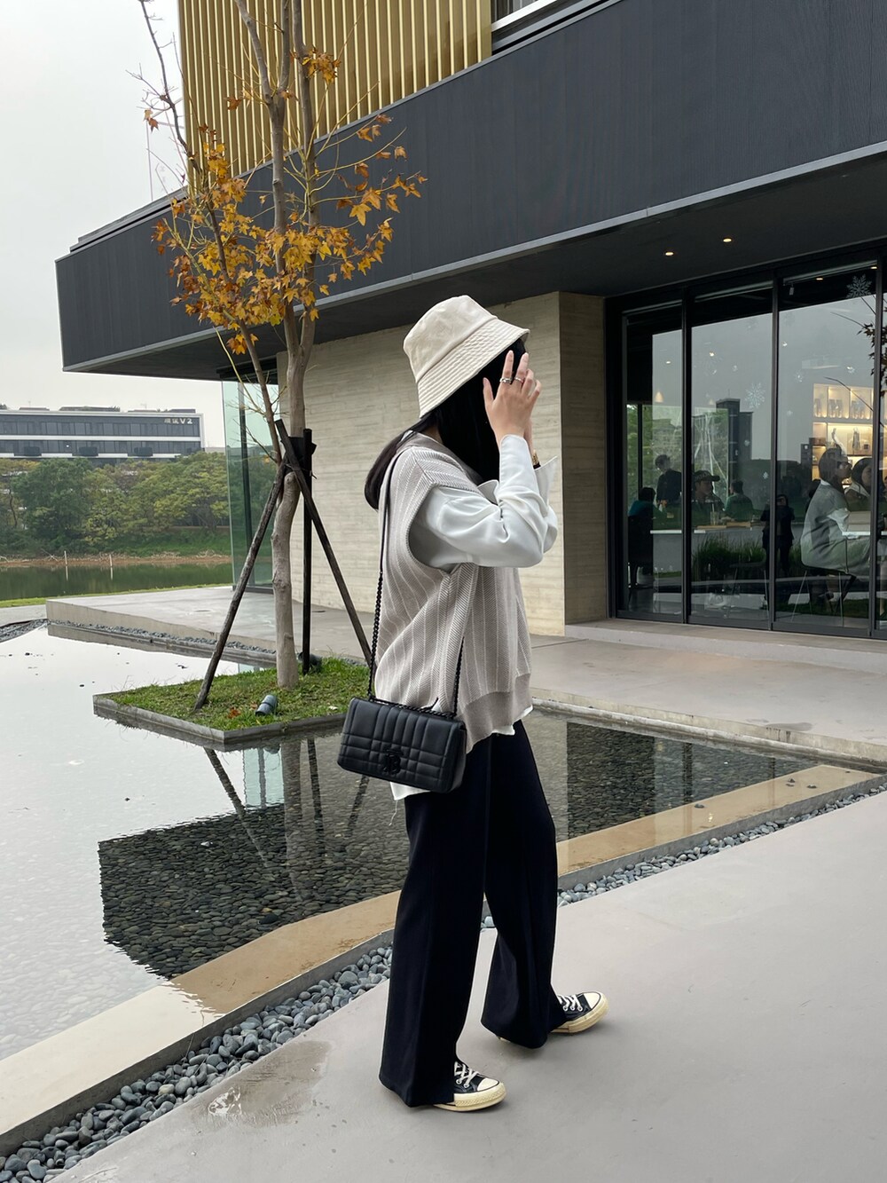 ブラック系のその他パンツ、ブラック系のショルダーバッグ、グレー系のベストを着用したレディースの冬コーディネートの2枚目の写真