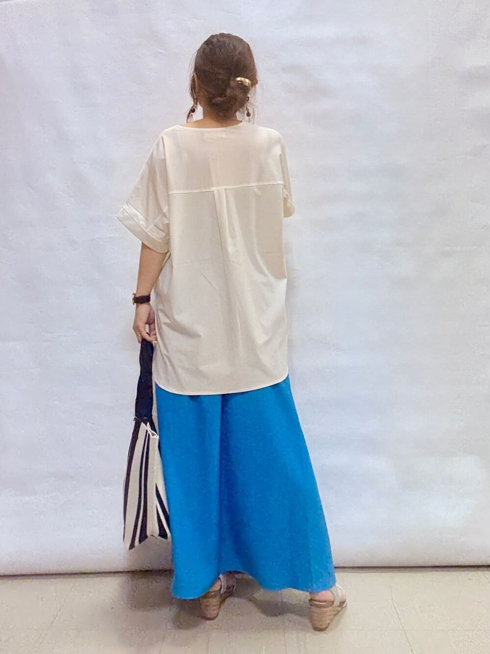 ホワイト系のTシャツ/カットソー、ブルー系のスカート、シルバー系のサンダルを着用したレディースの夏コーディネートの3枚目の写真