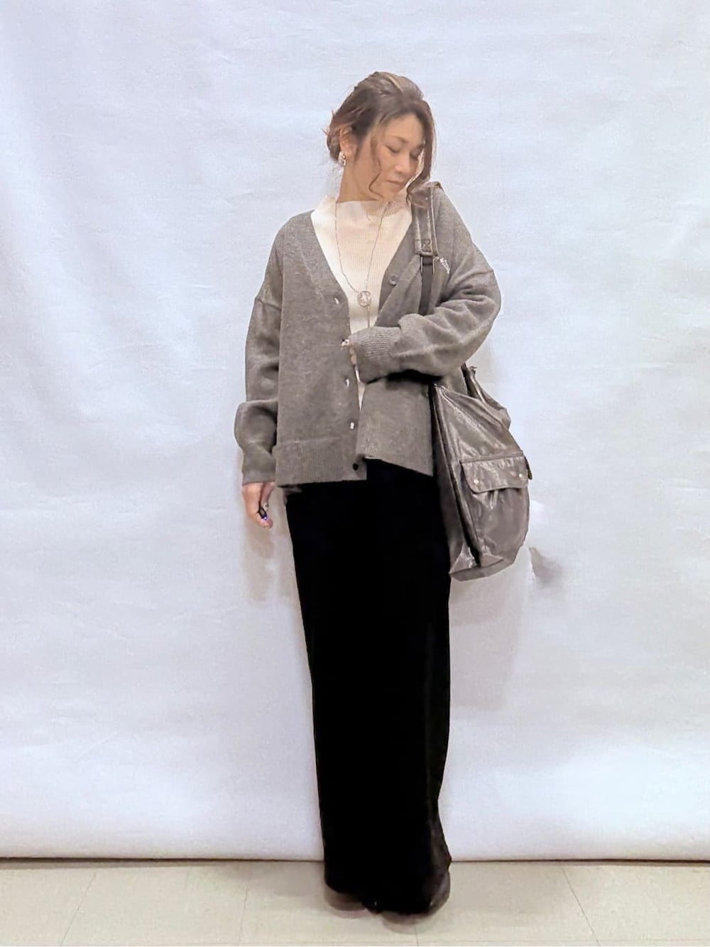 グレー系のカーディガン/ボレロ、ホワイト系のニット/セーター、ブラック系のその他パンツを着用したレディースの冬コーディネートの4枚目の写真