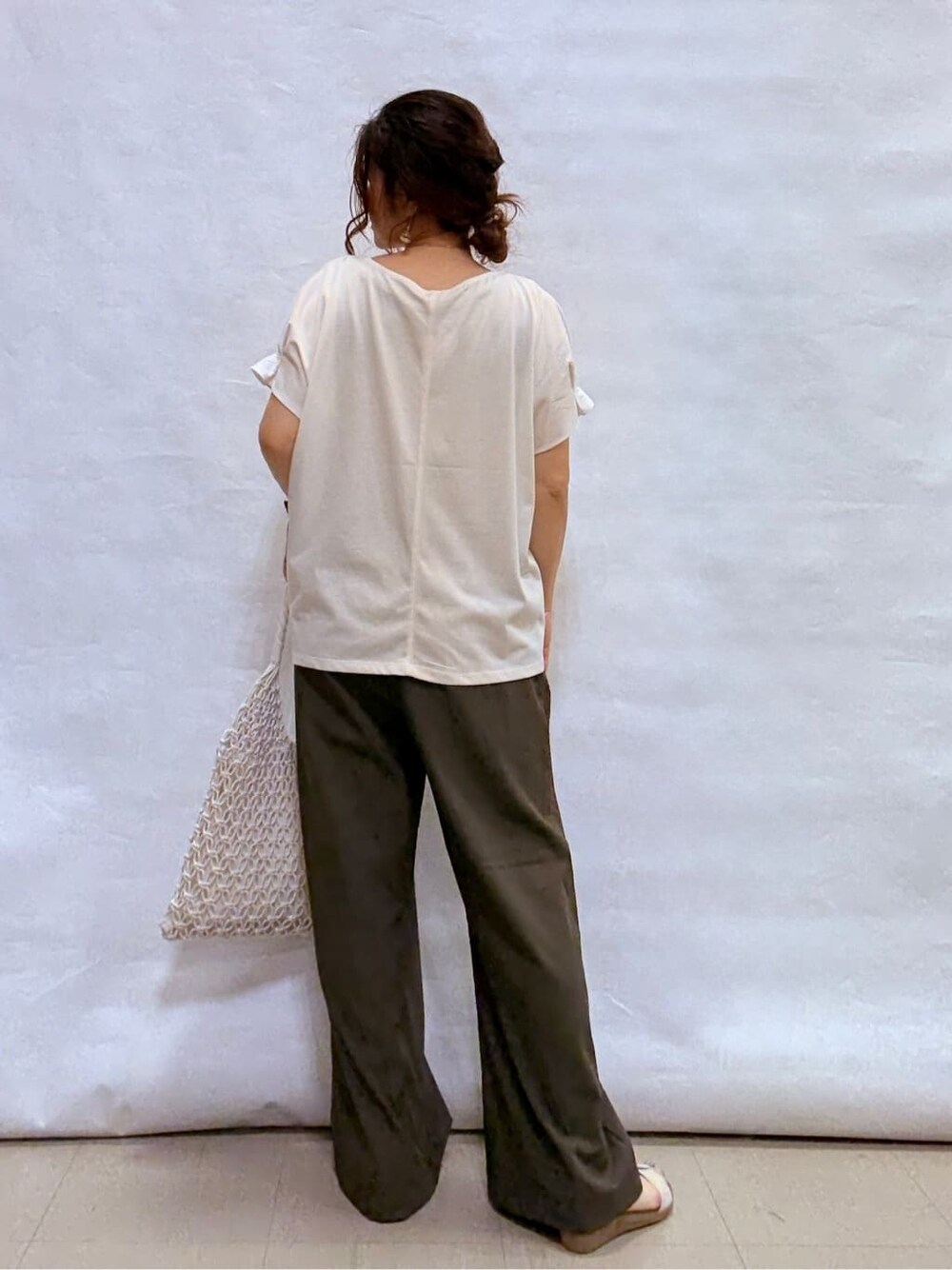 ホワイト系のTシャツ/カットソー、ブラウン系のその他パンツ、ゴールド系のサンダルを着用したレディースの夏コーディネートの6枚目の写真