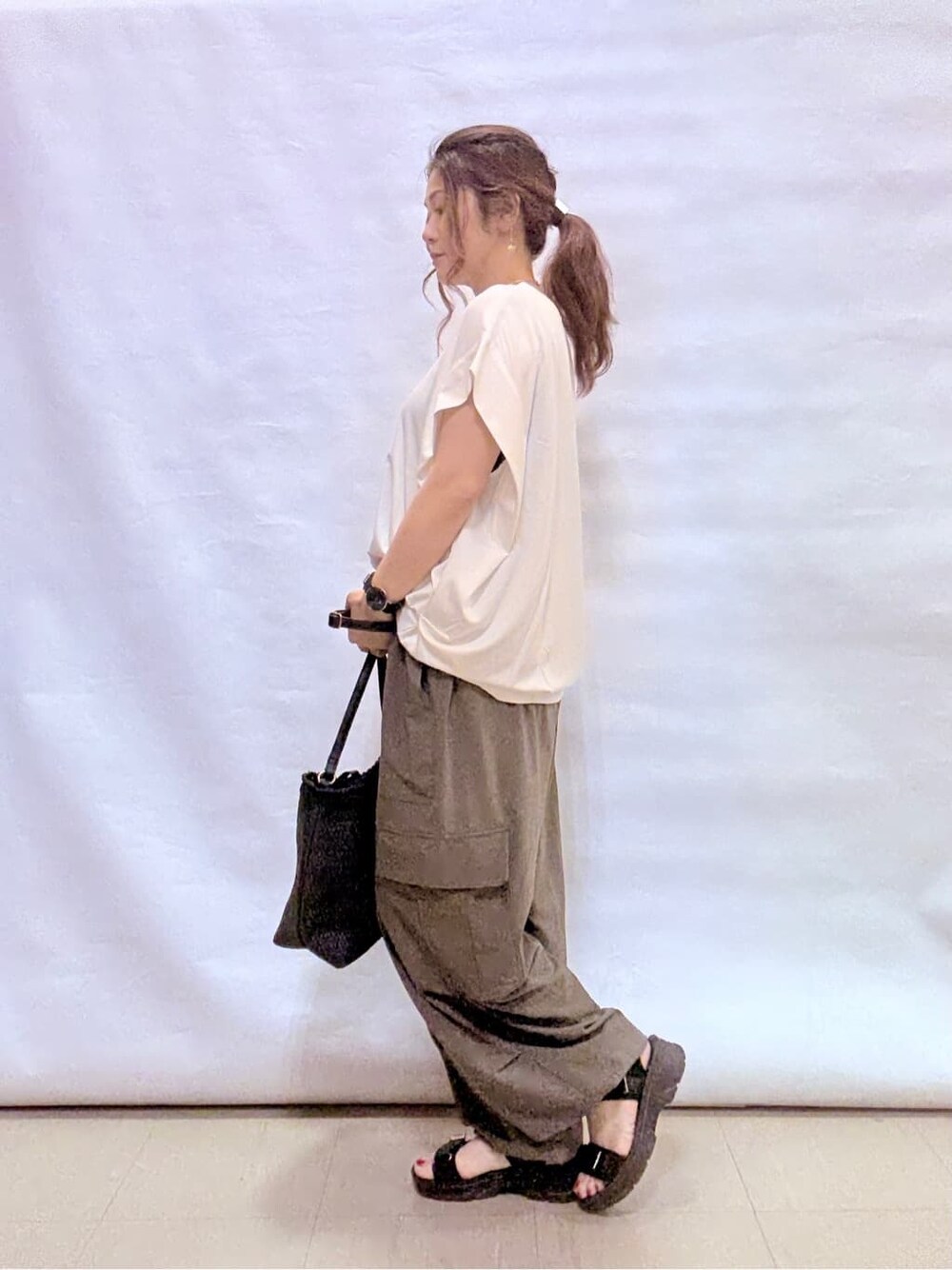 ホワイト系のTシャツ/カットソー、グリーン系のその他パンツ、ブラック系のサンダルを着用したレディースの夏コーディネートの2枚目の写真