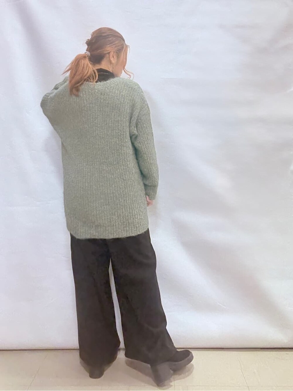 ベージュ系のダウンジャケット/コート、ブルー系のチュニック、ブラック系のTシャツ/カットソーを着用したレディースの冬コーディネートの6枚目の写真