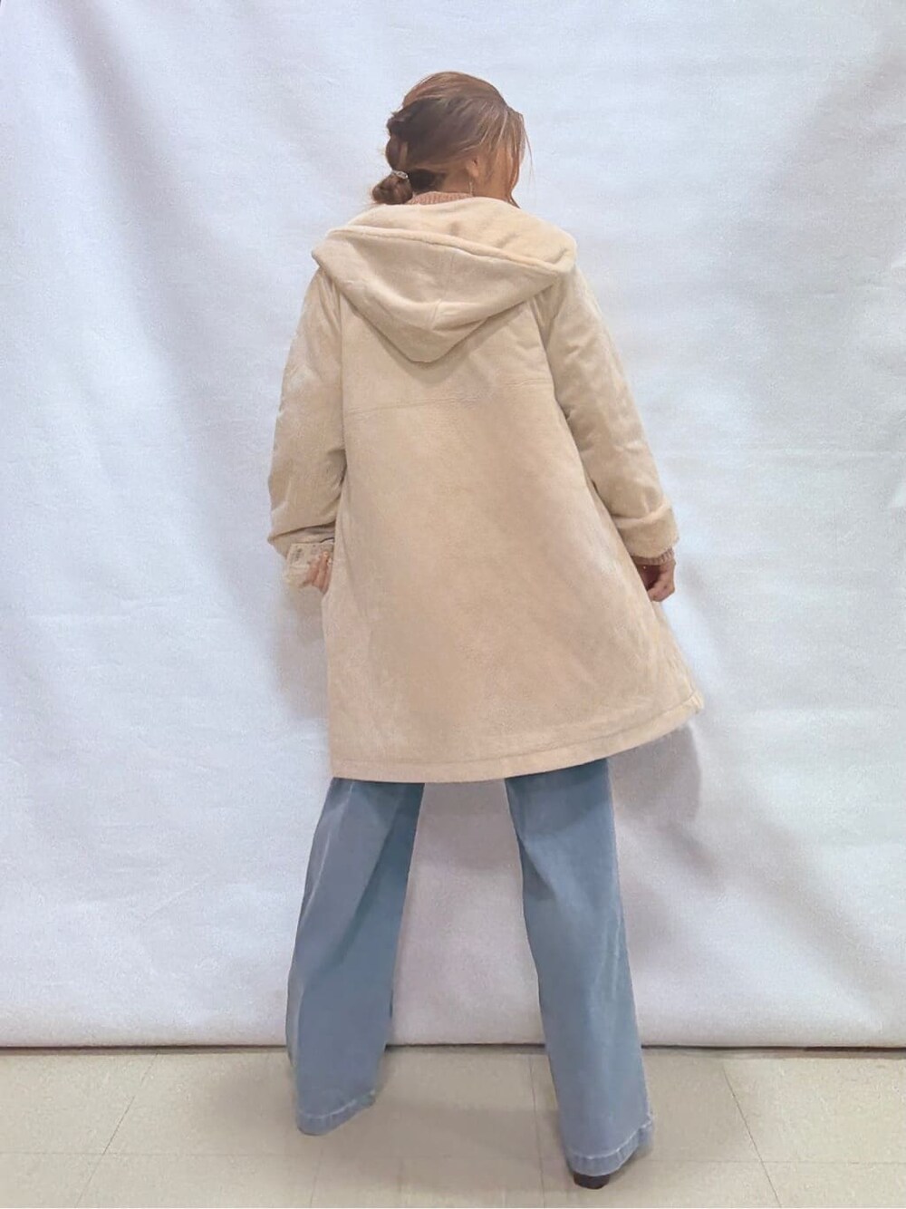 ホワイト系のその他アウター、ピンク系のニット/セーター、ブルー系のデニムパンツを着用したレディースの冬コーディネートの3枚目の写真