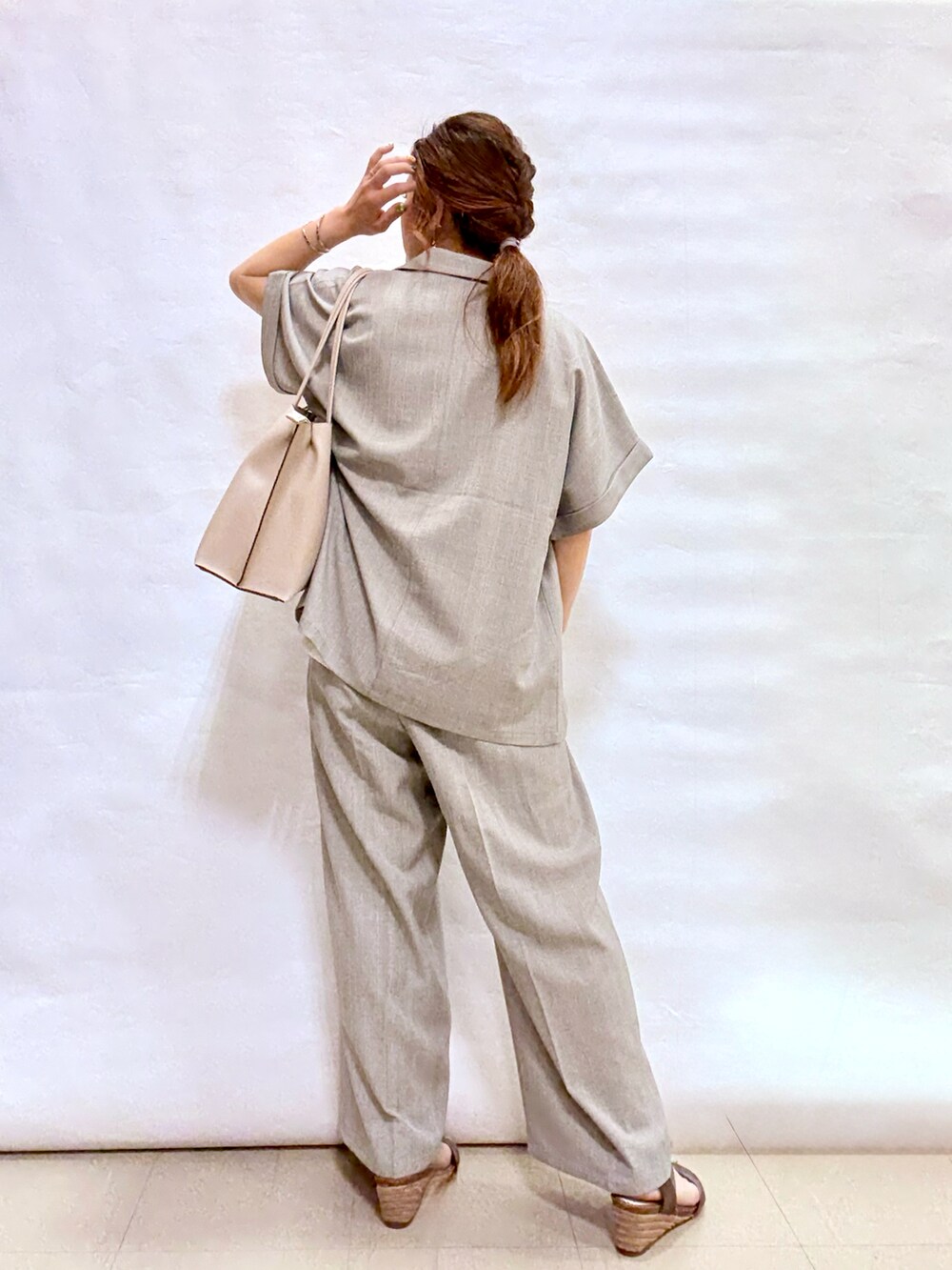 グレー系のテーラードジャケット、グレー系のトートバッグ、その他のサンダルを着用したレディースの夏コーディネートの3枚目の写真