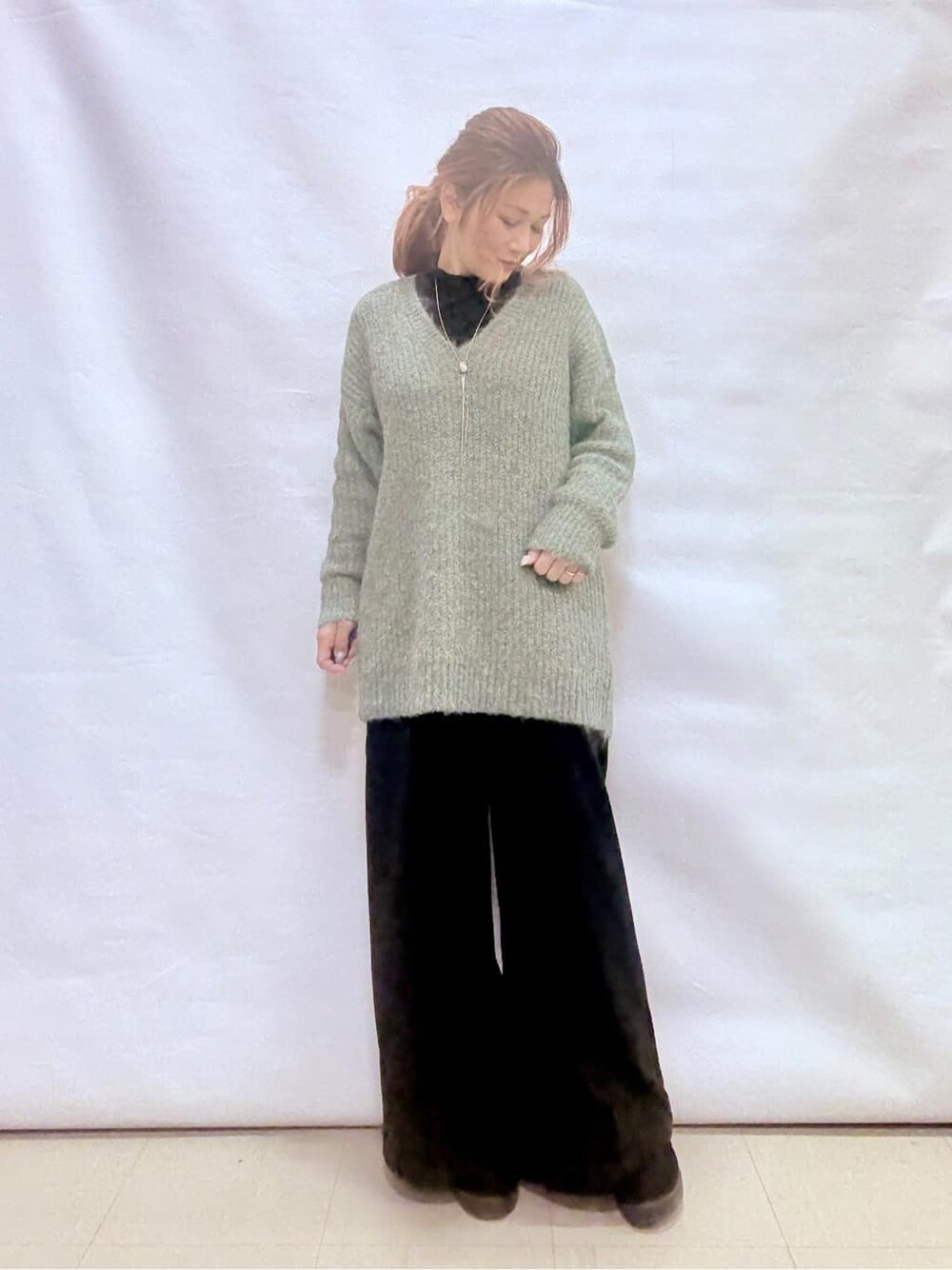 ベージュ系のダウンジャケット/コート、ブルー系のチュニック、ブラック系のTシャツ/カットソーを着用したレディースの冬コーディネートの4枚目の写真