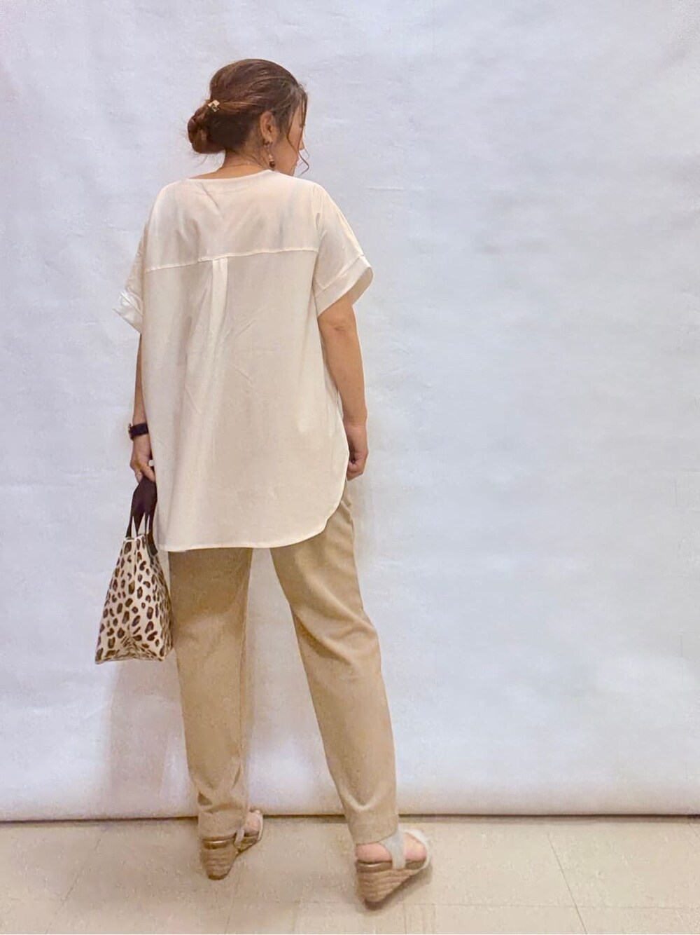 ホワイト系のTシャツ/カットソー、ベージュ系のその他パンツ、シルバー系のサンダルを着用したレディースの夏コーディネートの3枚目の写真