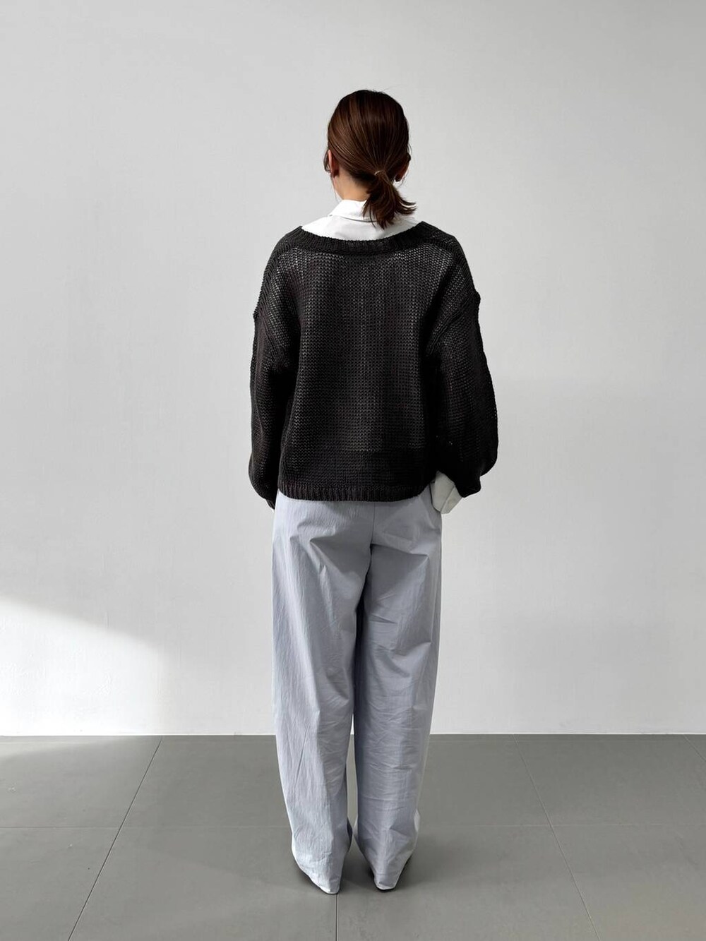 ホワイト系のハンドバッグ、ホワイト系のシャツ/ブラウス、ブラック系のサンダルを着用したレディースの冬コーディネートの8枚目の写真