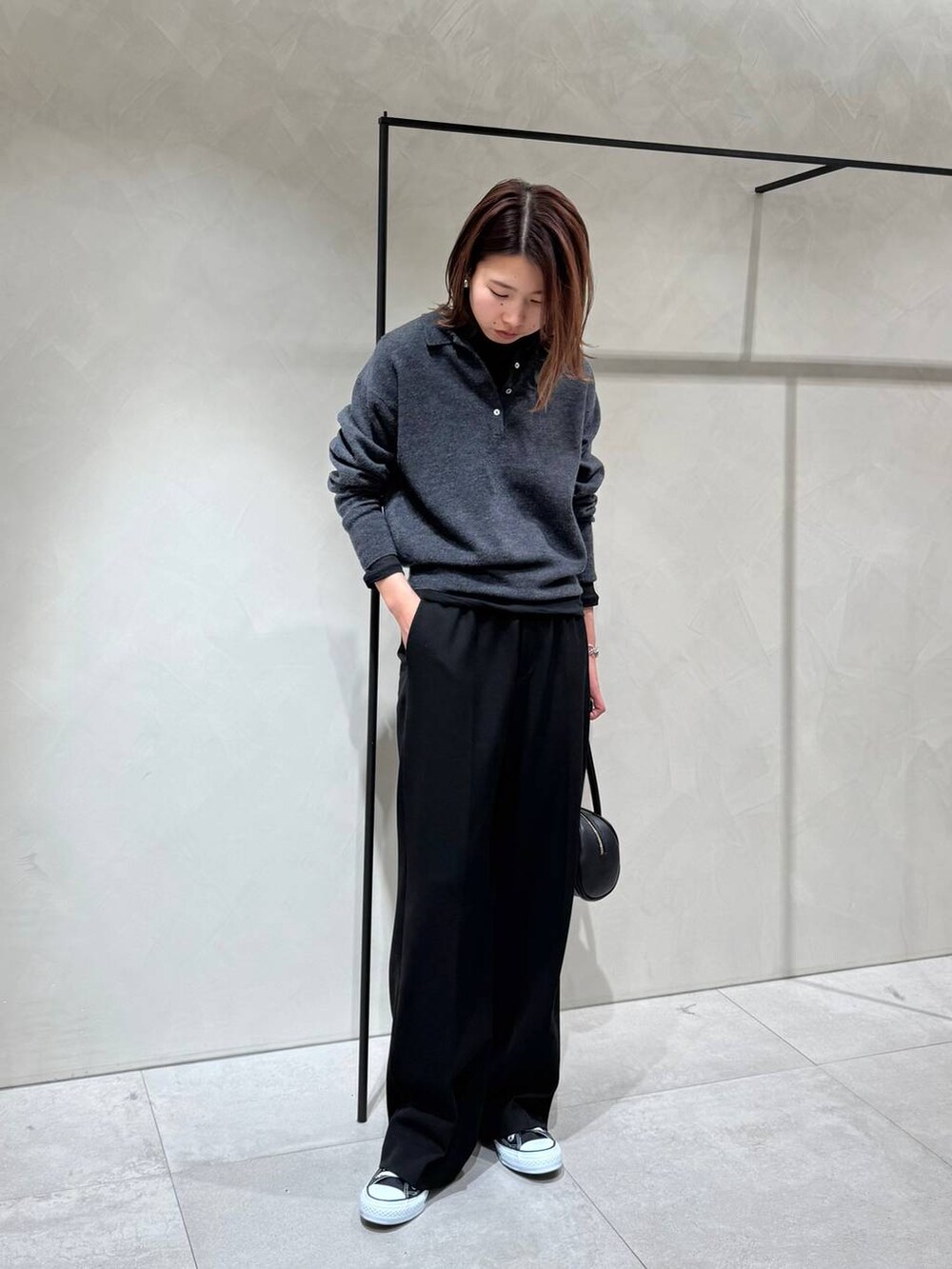 ブラック系のスニーカー、ブラック系のTシャツ/カットソー、グレー系のニット/セーターを着用したレディースの冬コーディネートの3枚目の写真