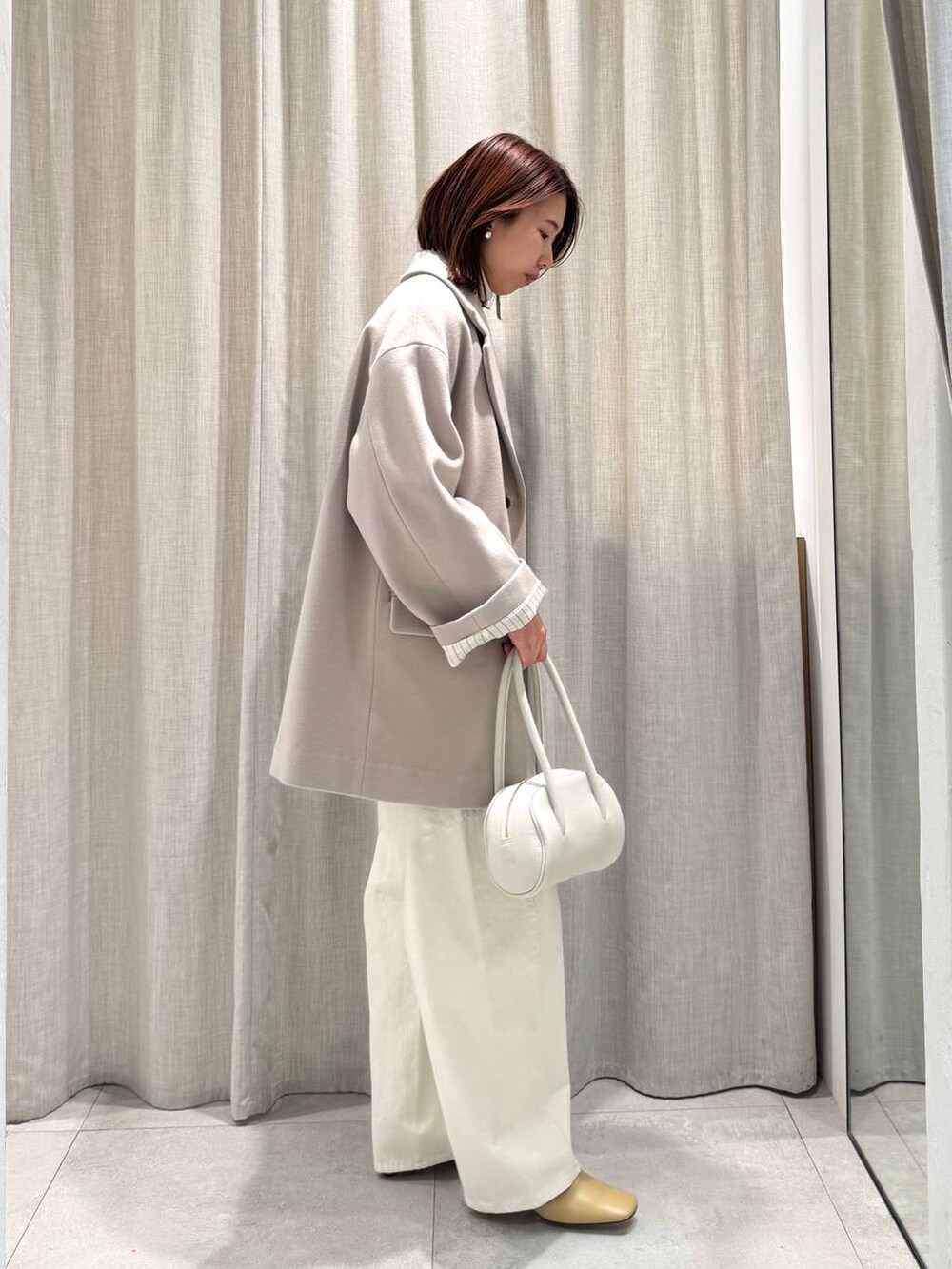 ホワイト系のニット/セーター、ベージュ系のテーラードジャケット、ベージュ系のカーディガン/ボレロを着用したレディースの冬コーディネートの7枚目の写真